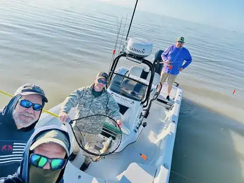 Anglers on the boat with a fish in the landing net, seen from above