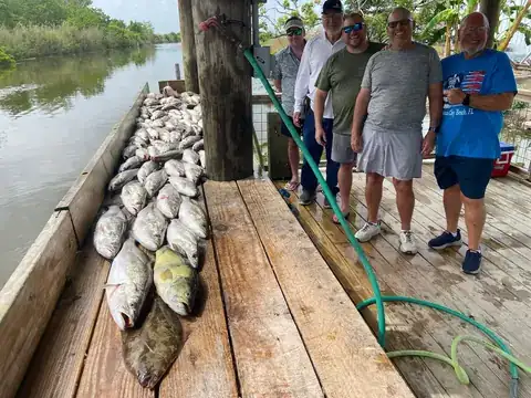 A group of anglers standing beside their catch on the dock in Venice, Louisiana