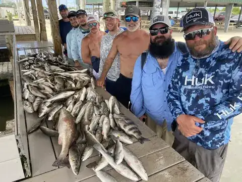 A large group of anglers beside their catch on the cleaning dock in Venice, Louisiana