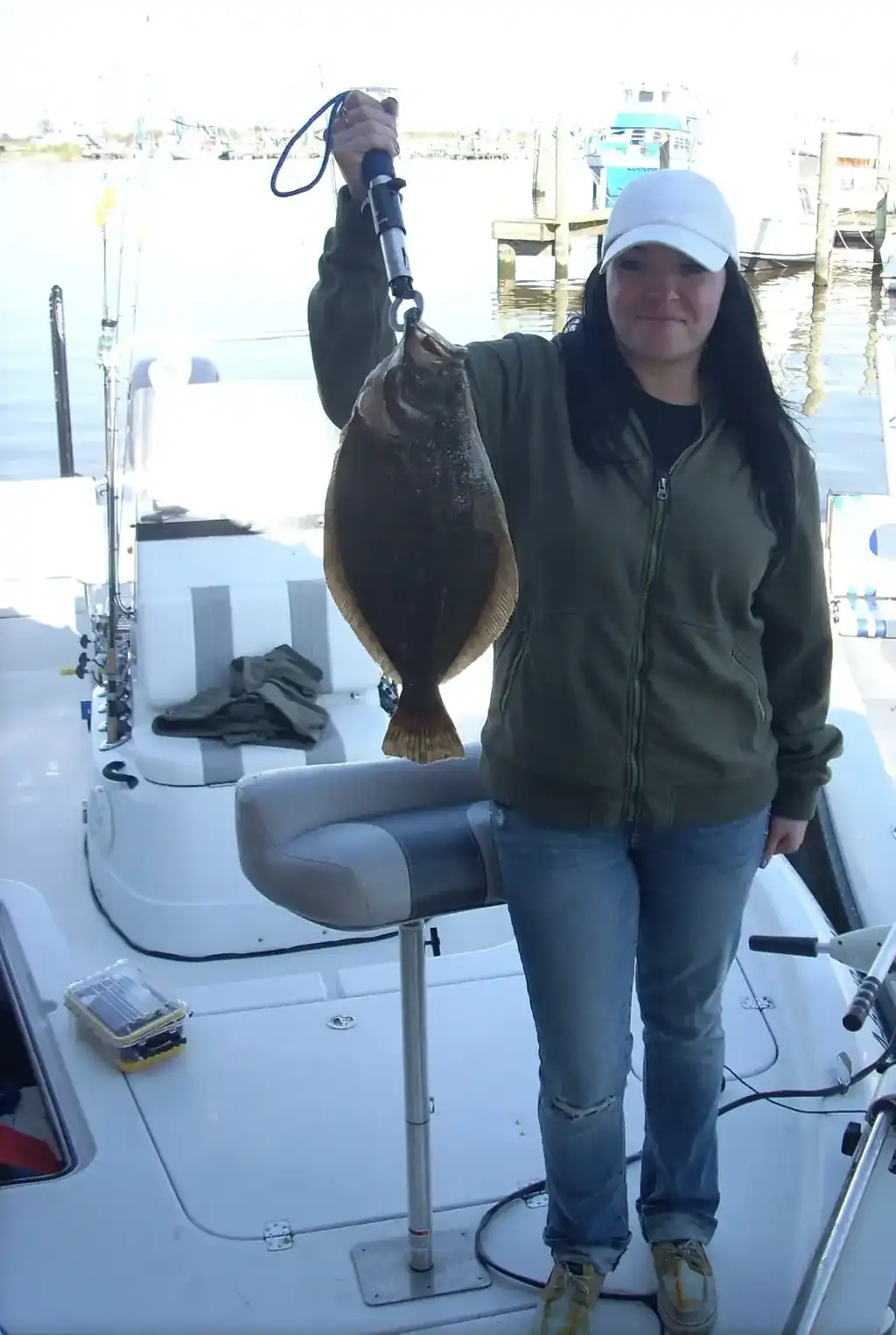 Angler holding up a flounder at the dock in Venice Marina
