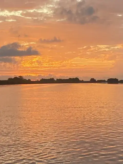 Orange clouds reflected in the water near Venice, Louisiana