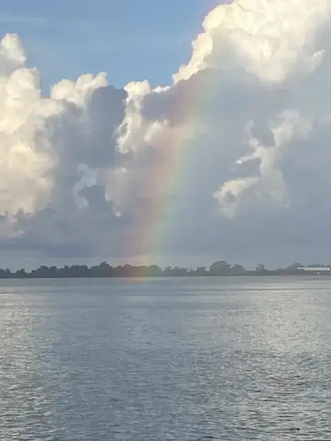 A rainbow in tall storm clouds over the water near Venice, Louisiana