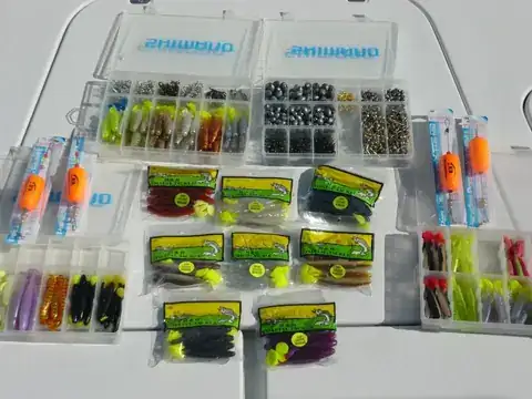 Tackle trays of soft plastic baits, jig heads and popping corks on the deck