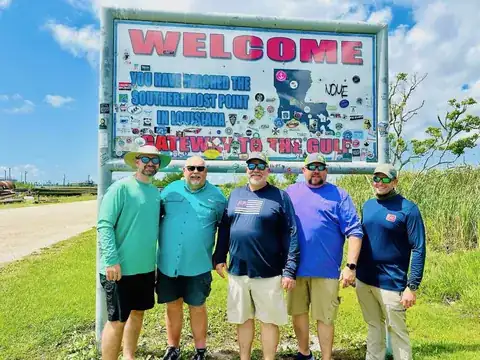 Five anglers standing under the Venice welcome sign for the southernmost point in Louisiana, gateway to the Gulf